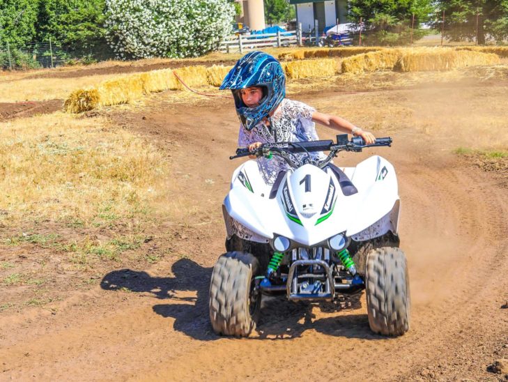 A camper riding an ATV with a helmet on.