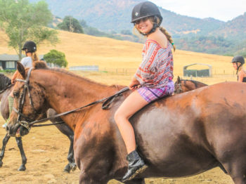 A camper riding bareback on a horse.