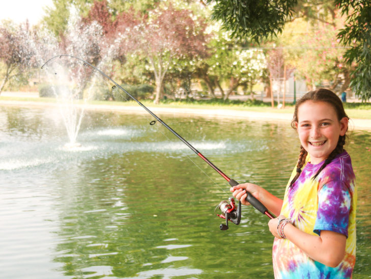 A camper smiling while fishing.