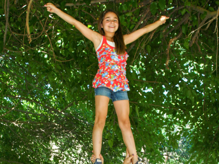 A camper learning how to stand in a cheer formation.