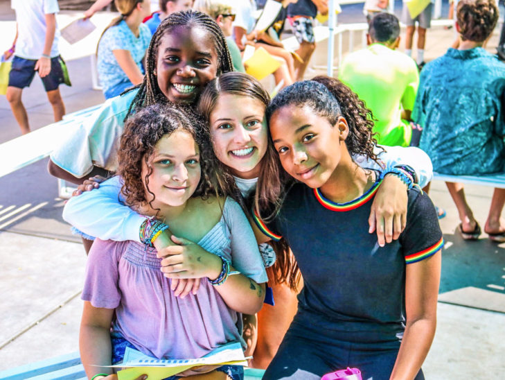 A group of campers with their arms around each other posing for the camera.