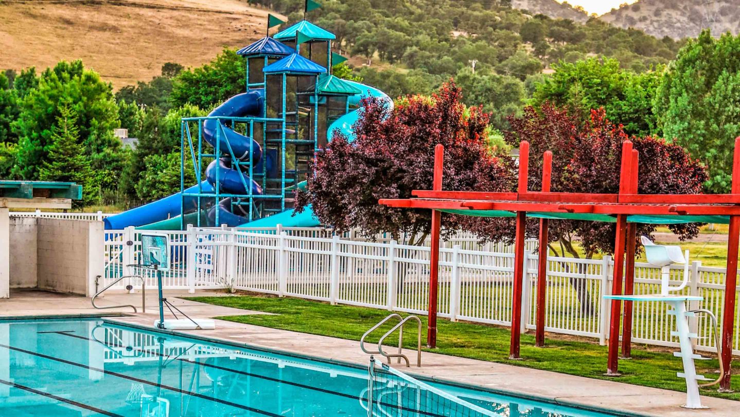 A pool with a slide going into it.