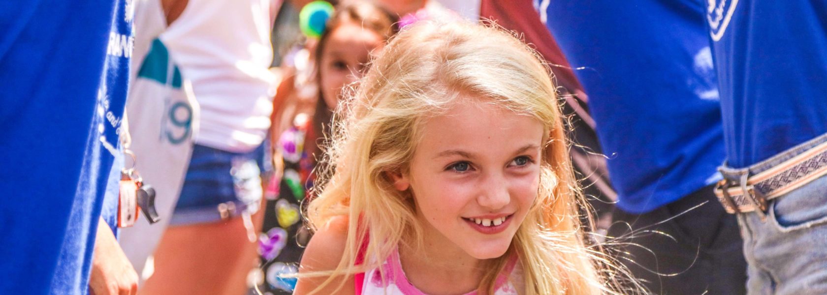 A young girl smiling as she is arriving for camp.