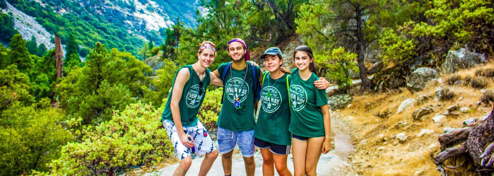 Counselors in training hiking through a mountain trail.