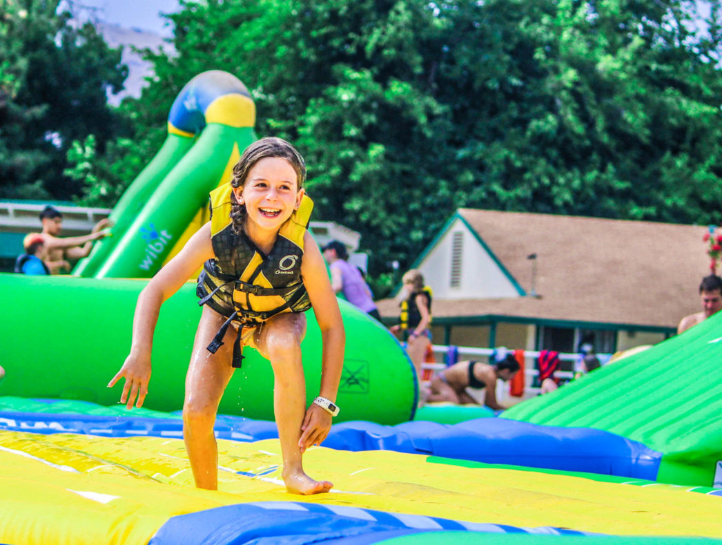 A camper playing on the water adventure course