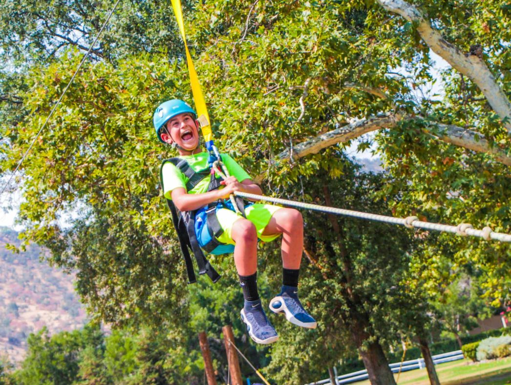 A camper on a zip line laughing