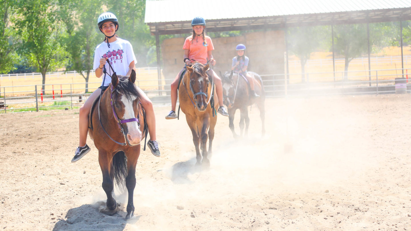 Campers riding horses