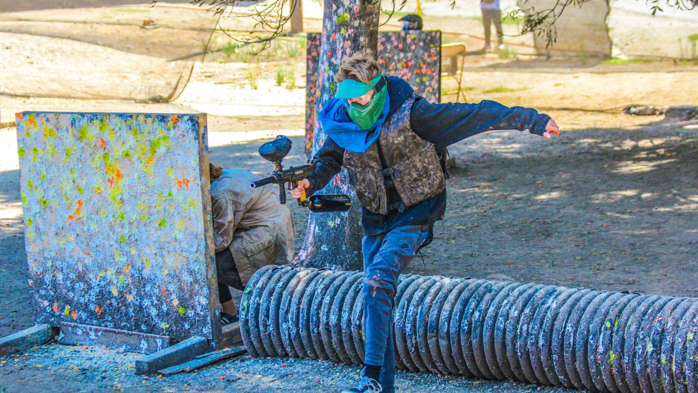 A camper running while playing paintball