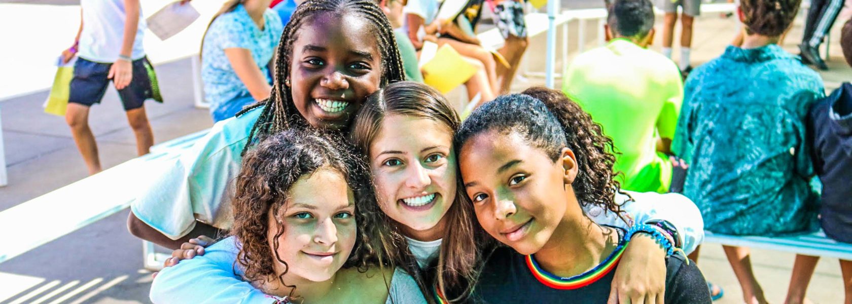 A group of campers with their arms around each other posing for the camera.