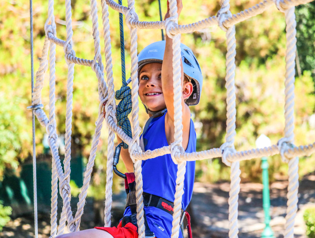 A camper climbing a rope net