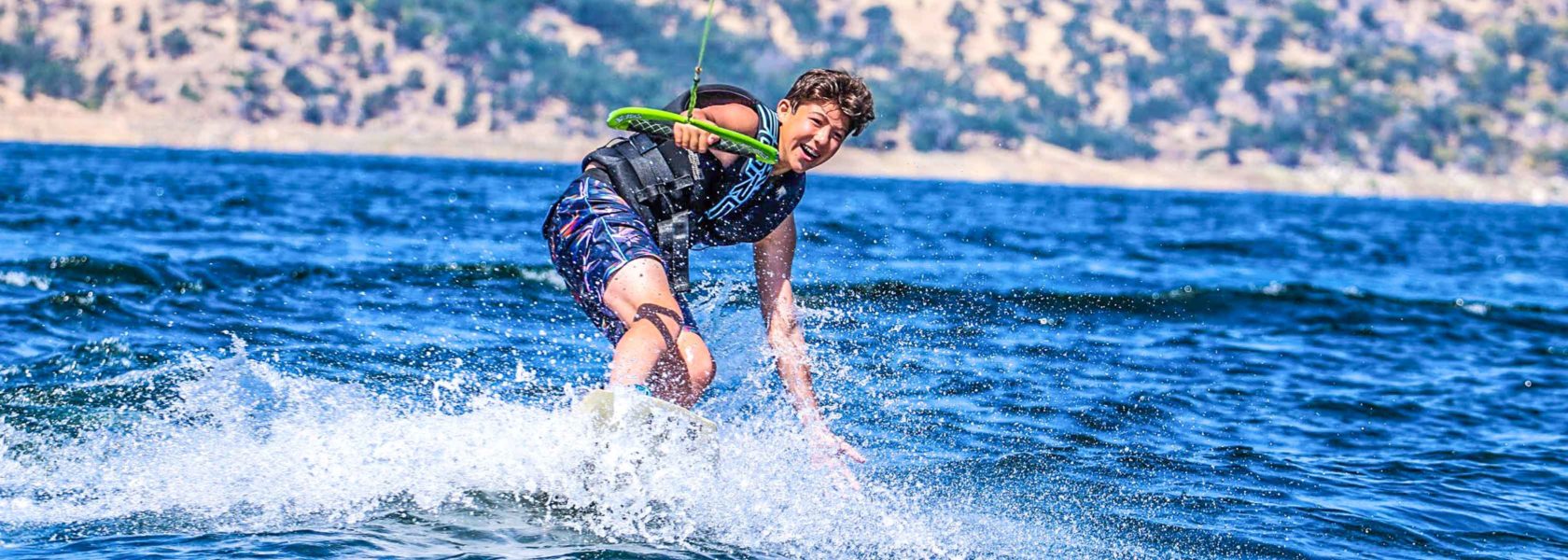 A camper having fun wakeboarding