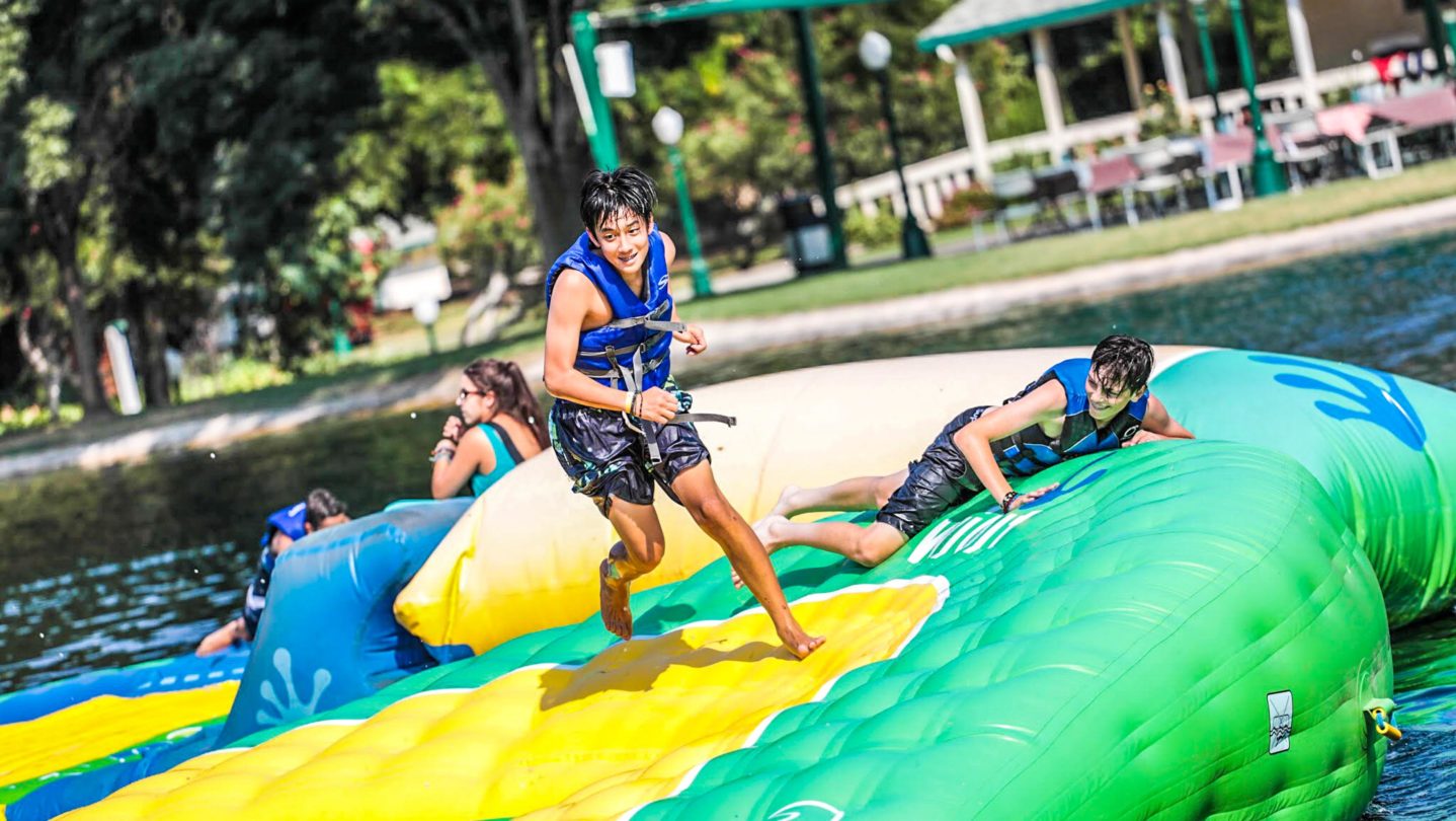 A camper exploring the inflatable adventure course