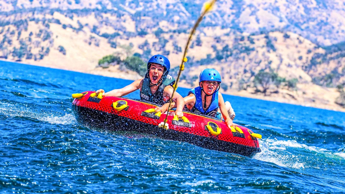 Campers having fun tubing on the lake