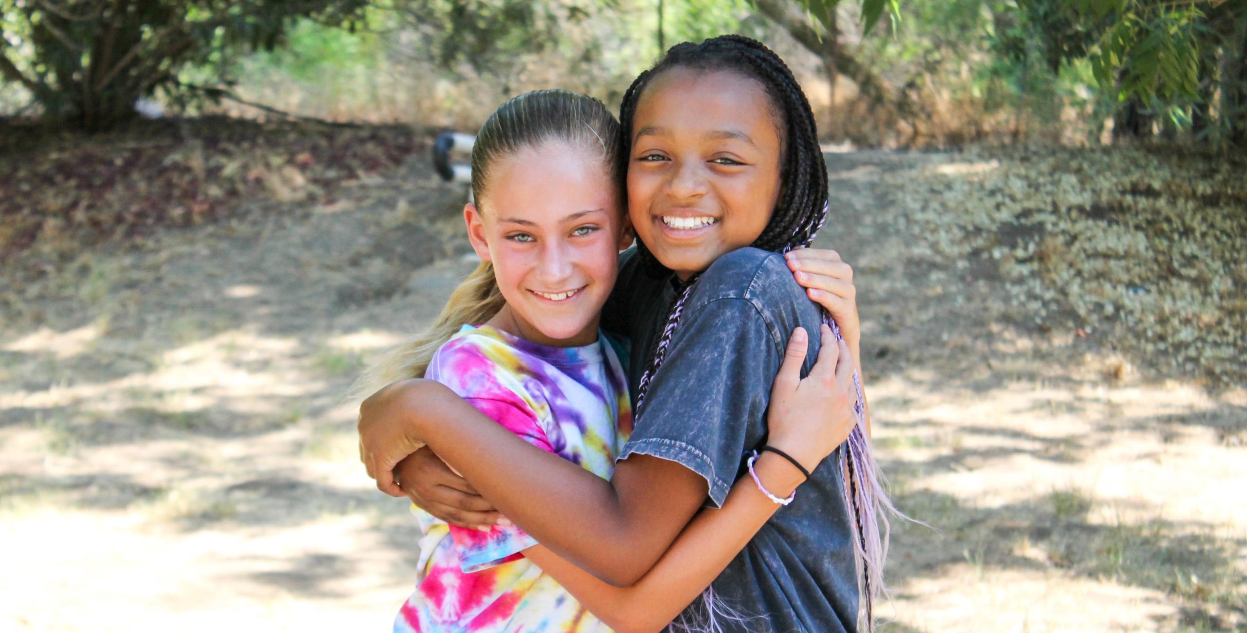 Campers hugging and smiling at the camera