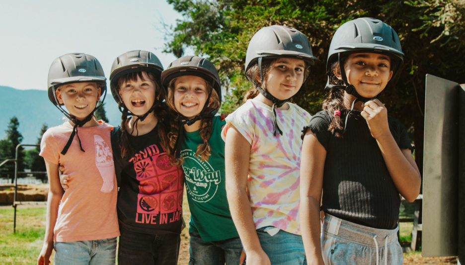 friends horseback riding at camp